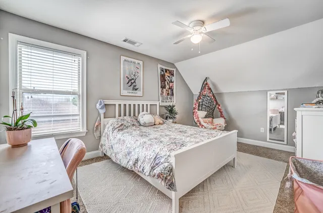 a bed sitting in a spacious bedroom next to a window