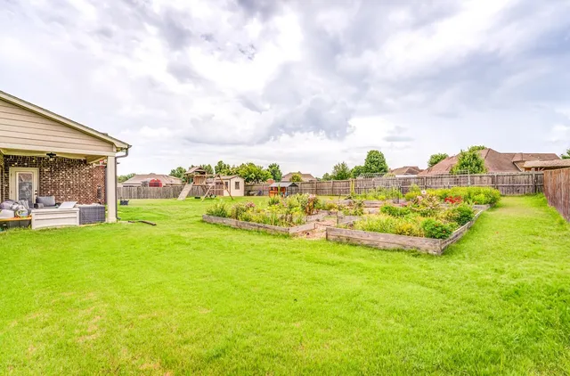 a view of a house with a big yard and large trees
