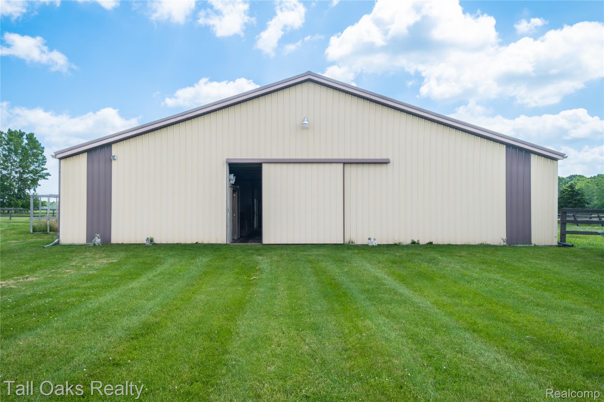 79330 Capac Road Armada, MI 48005 - Photo 14 of 42 Spacious outbuilding featuring a pitched roof, light-colored siding with dark trim accents, and a large sliding door entrance
