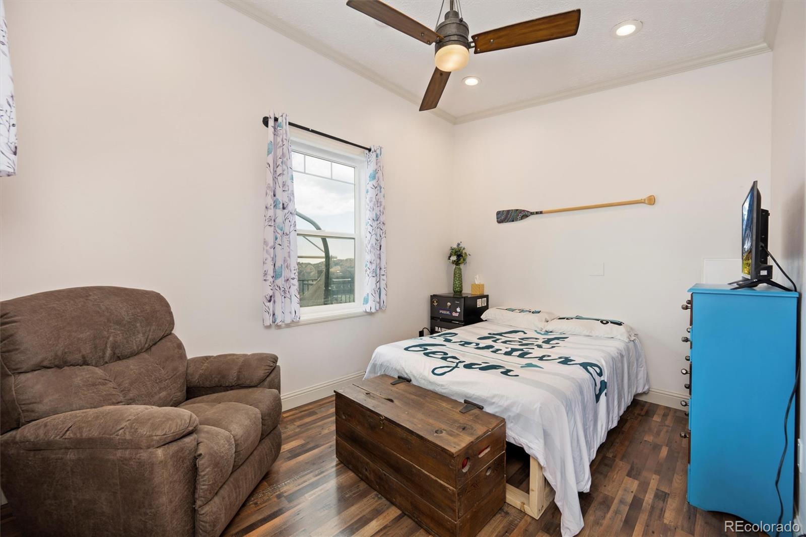 13328 Otter Road Loveland, CO 80538 - Photo 17 of 43 a bedroom with a bed couch and a window