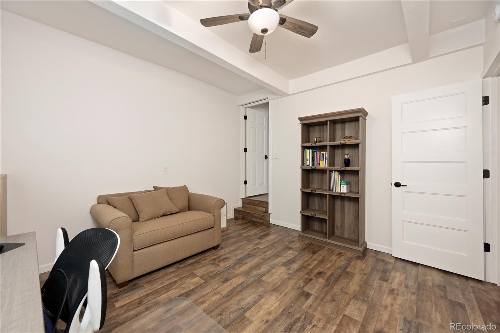 13328 Otter Road Loveland, CO 80538 - Photo 24 of 43 a living room with furniture and a chandelier