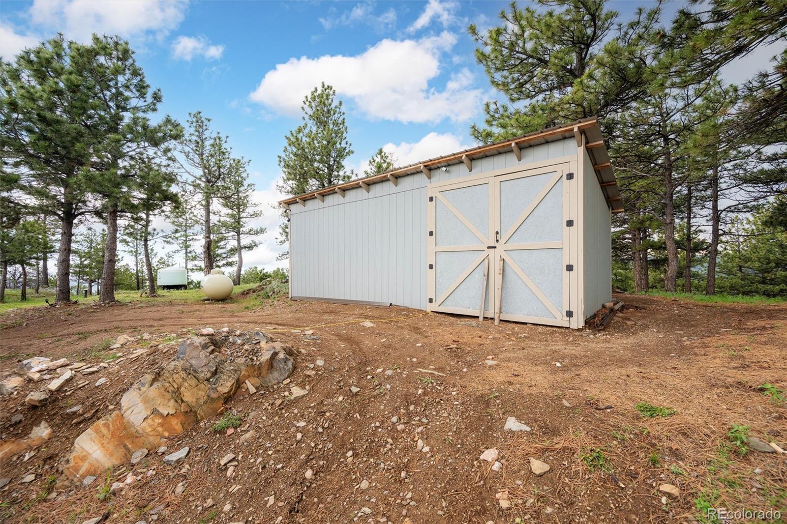 13328 Otter Road Loveland, CO 80538 - Photo 34 of 43 a view of a backyard with a large tree