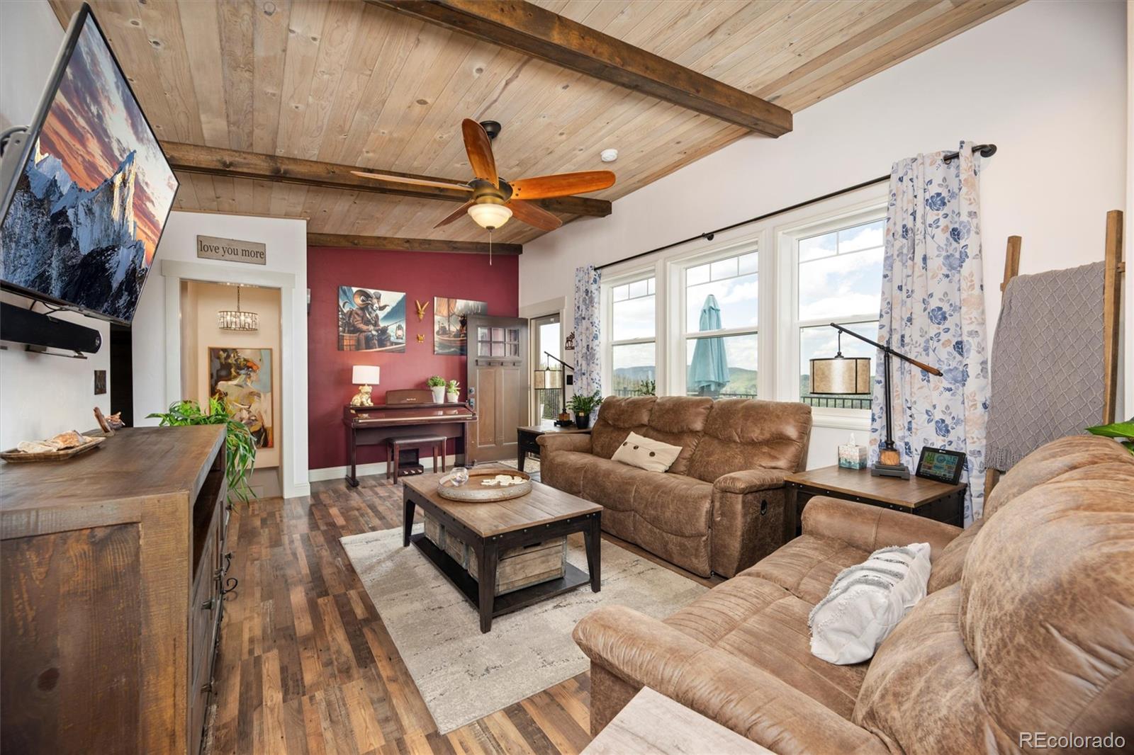13328 Otter Road Loveland, CO 80538 - Photo 6 of 43 a living room with furniture a fireplace and a large window