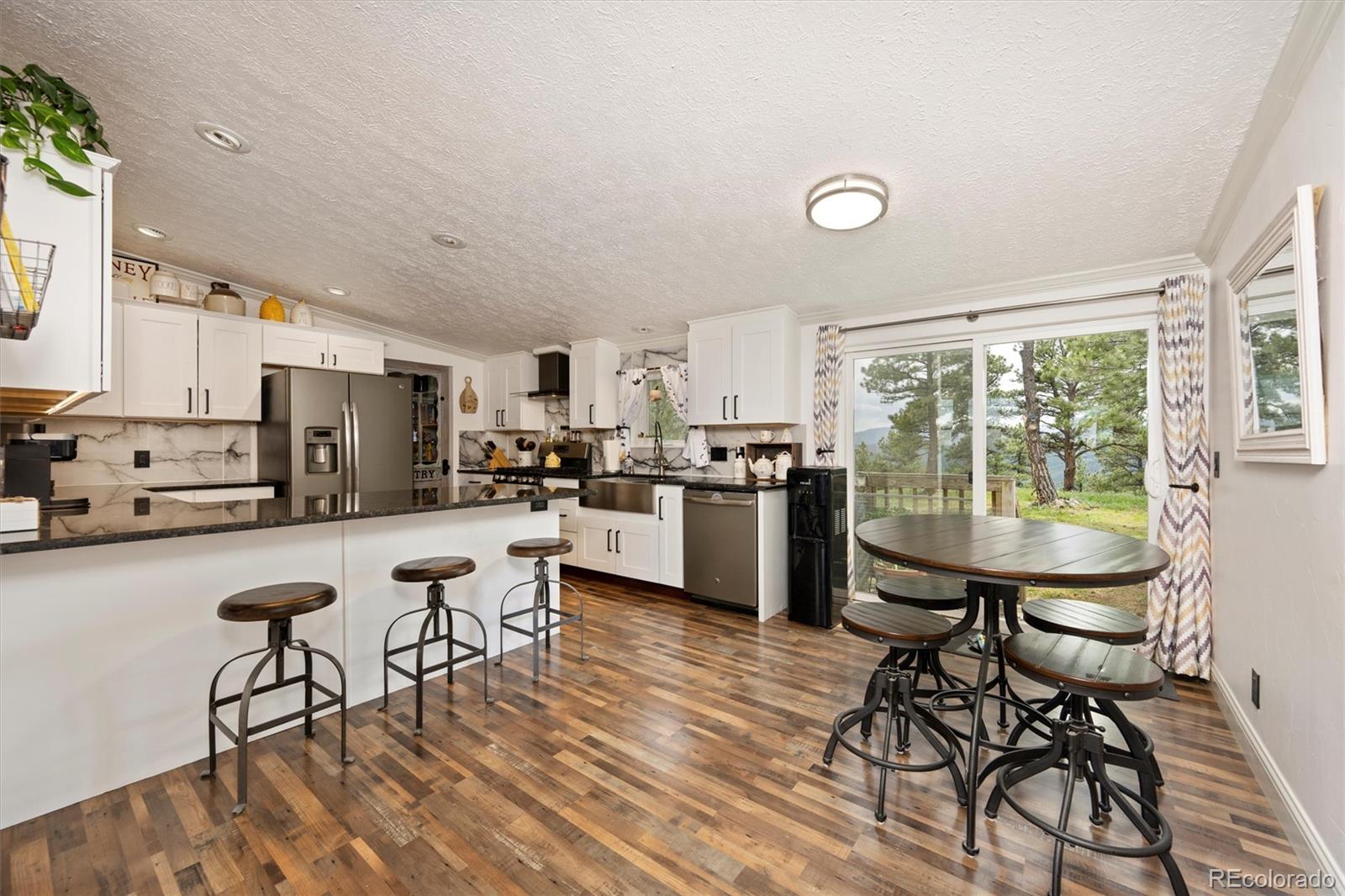 13328 Otter Road Loveland, CO 80538 - Photo 7 of 43 a kitchen with a table chairs a sink and appliances