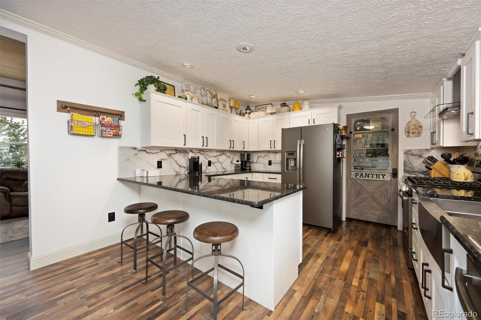13328 Otter Road Loveland, CO 80538 - Photo 8 of 43 a kitchen with stainless steel appliances granite countertop a refrigerator and a stove top oven