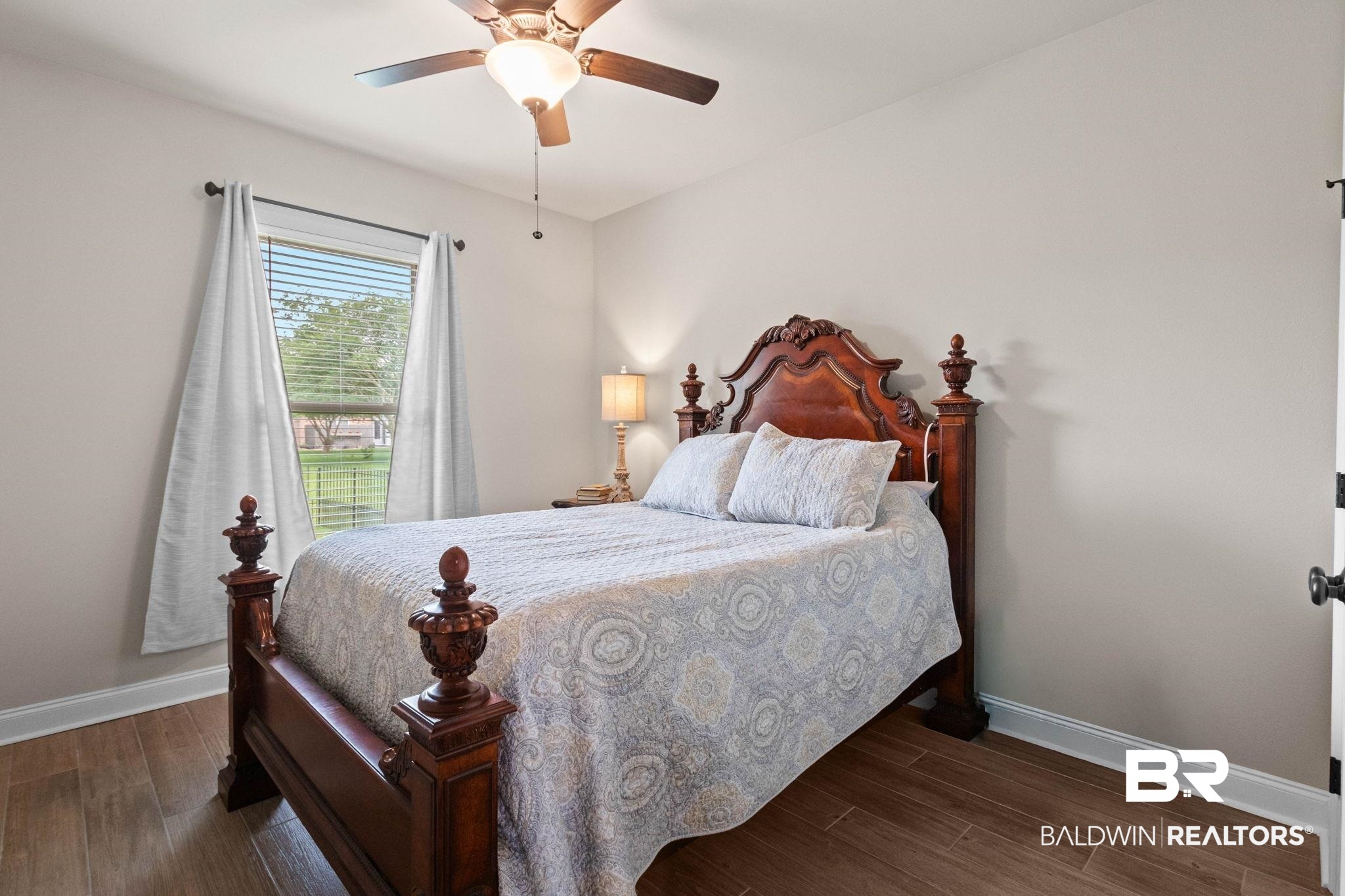 22244 Hibiscus Circle Foley, AL 36535 - Photo 42 of 51 Bedroom with wood-finish flooring, a window featuring blinds and light-colored drapes, a ceiling fan with integrated lighting, and white baseboards