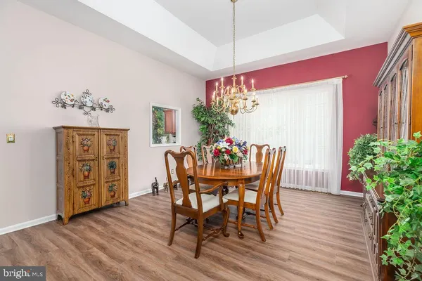 a dining room with furniture potted plants and wooden floor