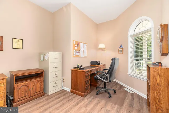 a view of a workspace with furniture and a window