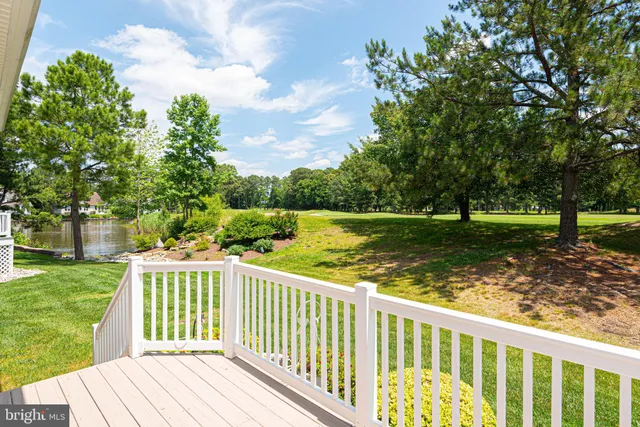a view of a wooden deck and a yard with wooden fence