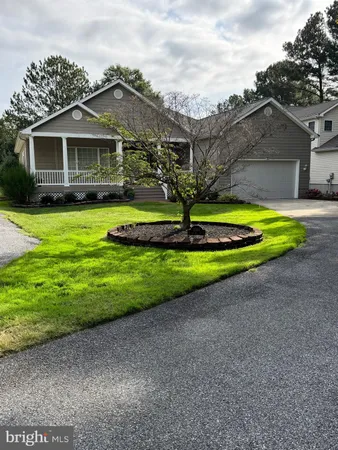 a front view of a house with a yard and trees