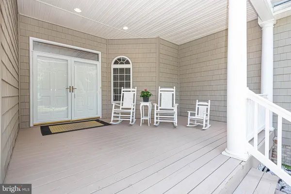 a view of an empty room with wooden floor and windows
