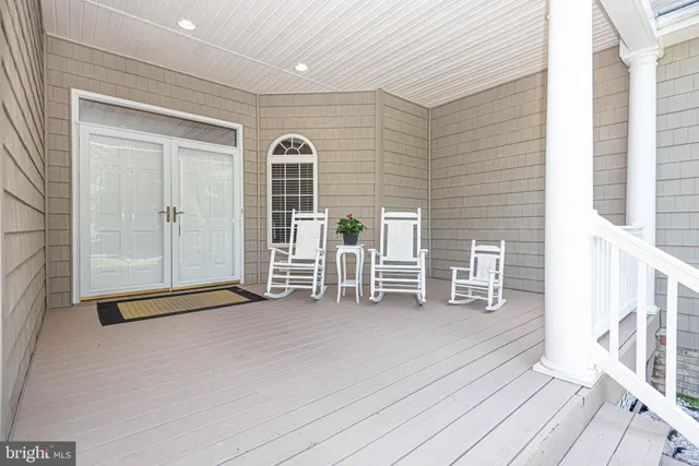 a view of an empty room with wooden floor and windows