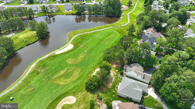 an aerial view of a house with a garden and lake view