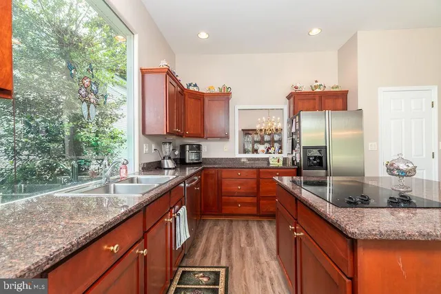 a kitchen with stainless steel appliances granite countertop a sink a stove and a refrigerator