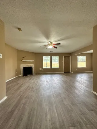 a view of empty room with wooden floor and fireplace