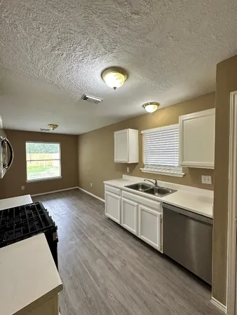 a kitchen with stainless steel appliances a stove a sink and a refrigerator