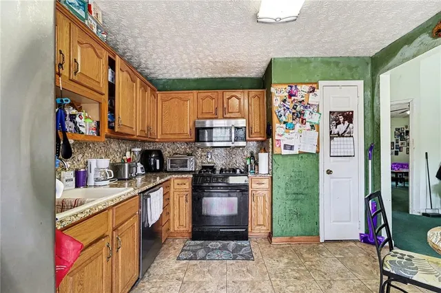a kitchen with stainless steel appliances granite countertop a refrigerator and a stove top oven