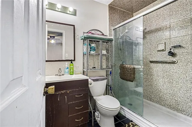 a bathroom with a granite countertop toilet sink and mirror