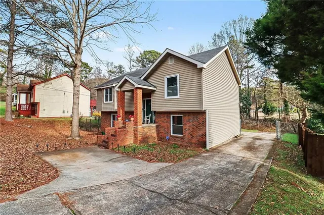 a view of a house with a yard and trees
