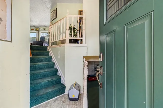 a view of a hallway with wooden floor and entryway