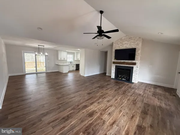 a view of empty room with wooden floor and fireplace
