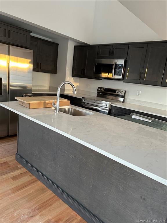 3 Banner Road, Unit 107 East Haddam, CT 06469 - Photo 15 of 18 a kitchen with stainless steel appliances a sink a stove a microwave a counter top space and cabinets