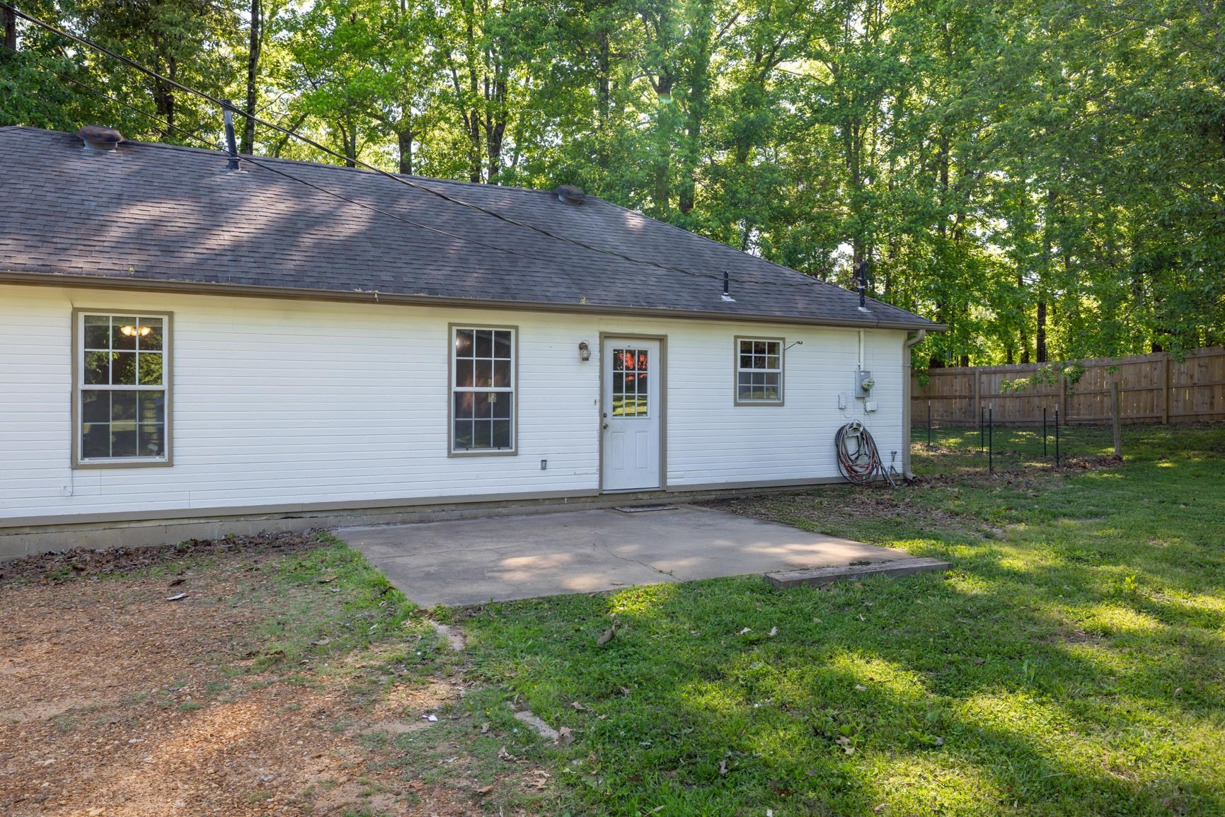 366 Adkins Road Burlison, TN 38015 - Photo 16 of 20 Rear exterior featuring white siding, a concrete patio, and a wood privacy fence