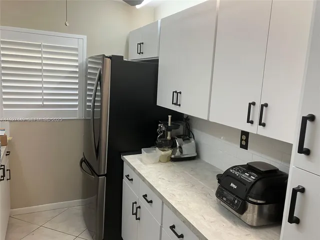 a kitchen with a refrigerator and a stove top oven