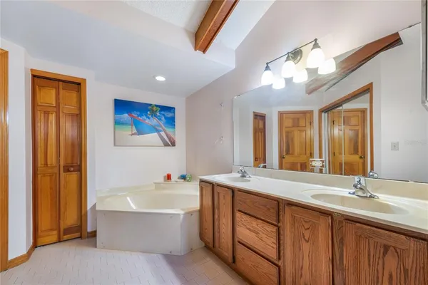 a bathroom with a granite countertop sink mirror and a bathtub