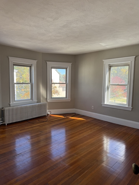 21 St George Avenue, Unit 3 Norwood, MA 02062 - Photo 3 of 5 an empty room with wooden floor and windows