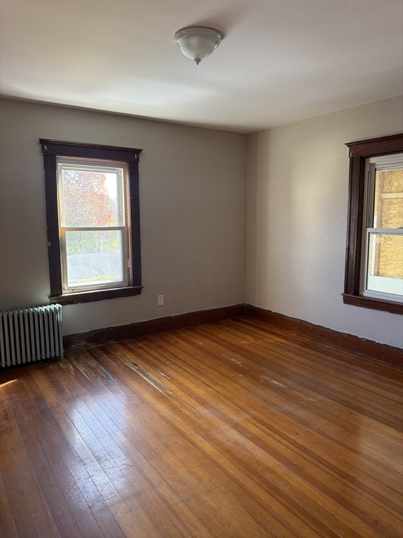 21 St George Avenue, Unit 3 Norwood, MA 02062 - Photo 5 of 5 an empty room with wooden floor and windows