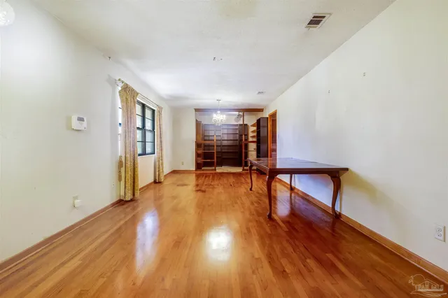 a view of empty room with window and wooden floor