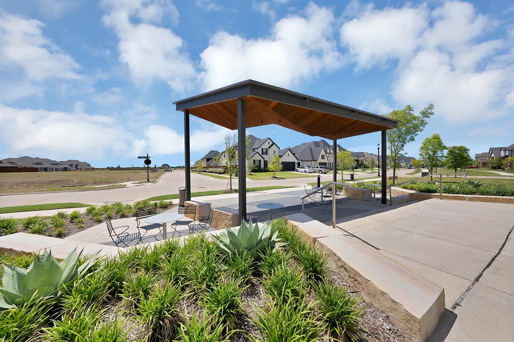5012 Triadic Lane Prosper, TX 75078 - Photo 35 of 38 Modern outdoor pavilion with a wood-finish ceiling, dark metal supports, and integrated overhead lighting