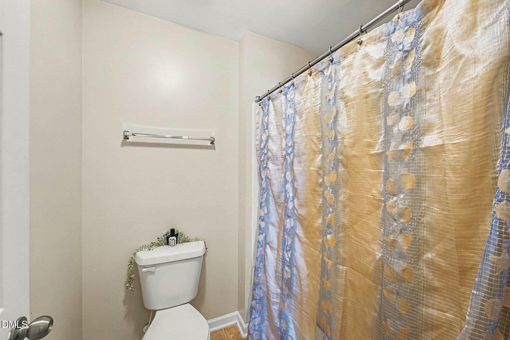 1130 Renewal Place, Unit 106 Raleigh, NC 27603 - Photo 17 of 34 a white toilet sitting next to a shower curtain