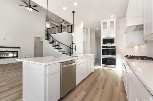 a kitchen with appliances cabinets and a wooden floor
