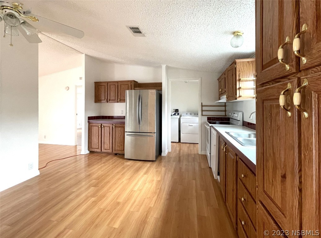 4391 Maple Avenue Edgewater, FL 32141 - Photo 11 of 50 a kitchen with a sink a refrigerator and wooden floor