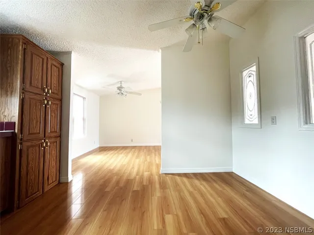a view of an empty room with window and wooden floor