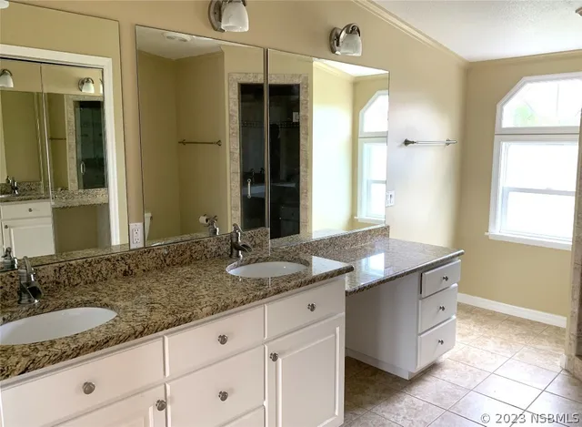 a bathroom with a granite countertop sink a toilet a mirror and shower