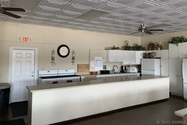 a kitchen with a stove a refrigerator and a clock