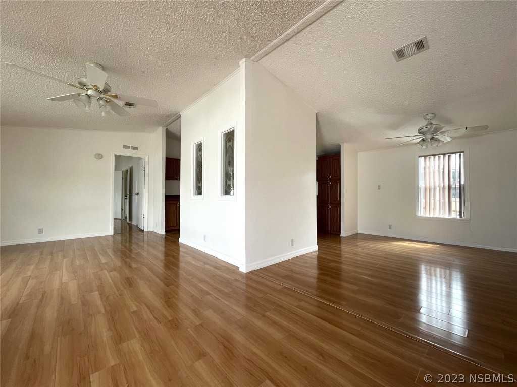 4391 Maple Avenue Edgewater, FL 32141 - Photo 7 of 50 a view of an empty room with wooden floor and a kitchen