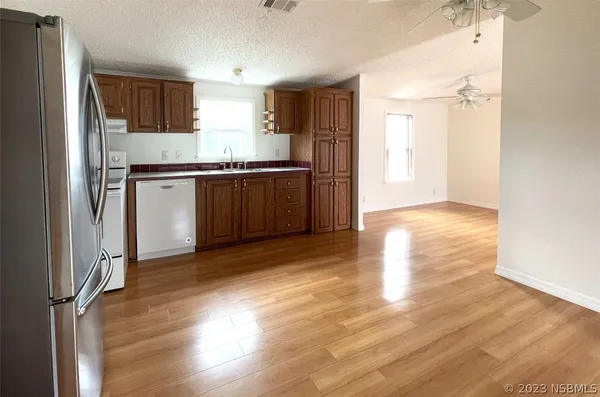 a kitchen with granite countertop a refrigerator stove top oven and sink