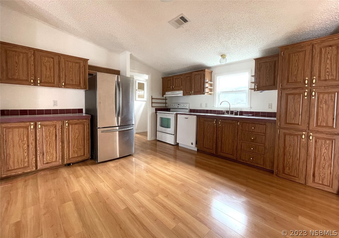 4391 Maple Avenue Edgewater, FL 32141 - Photo 10 of 50 a kitchen with granite countertop a refrigerator stove top oven and sink