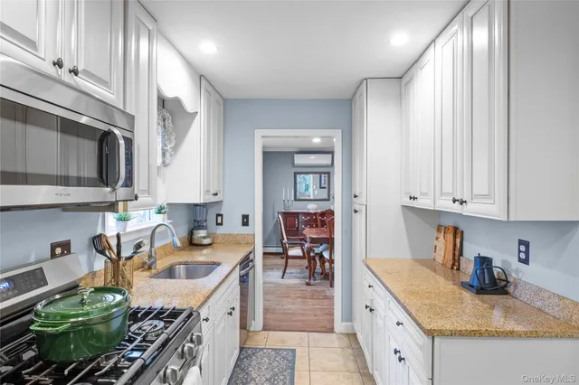 a kitchen with granite countertop a sink a stove and cabinets