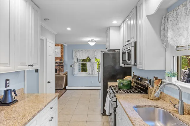 a kitchen with stainless steel appliances granite countertop a sink refrigerator and cabinets