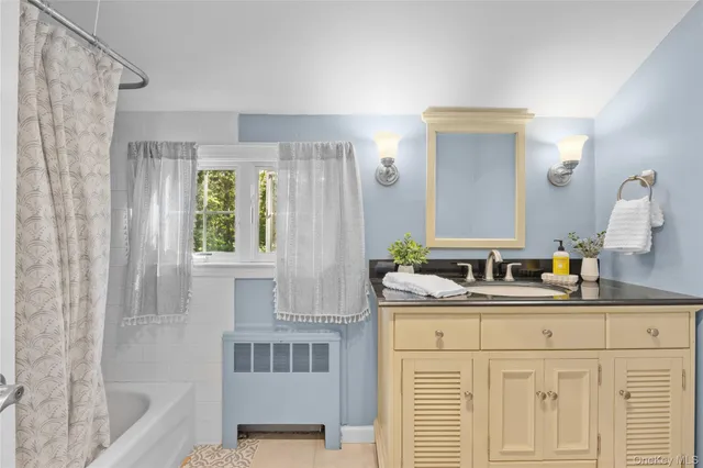 a bathroom with a tub sink and mirror