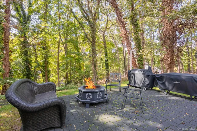 a view of a patio with table and chairs and a barbeque