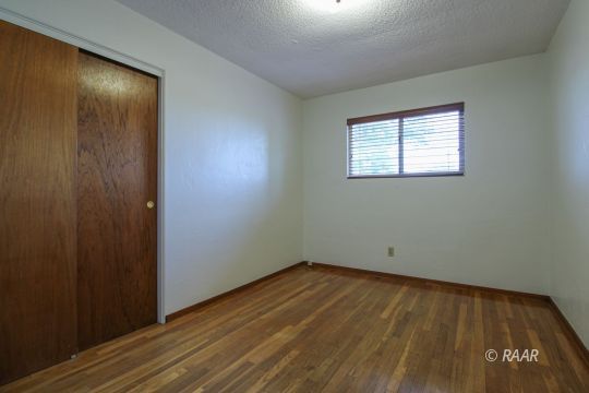 251 West Perdew Avenue Ridgecrest, CA 93555 - Photo 22 of 35 an empty room with wooden floor and windows
