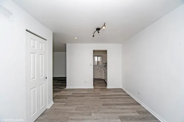 a view of a hallway with wooden floor and closet