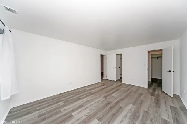 a view of an empty room with wooden floor