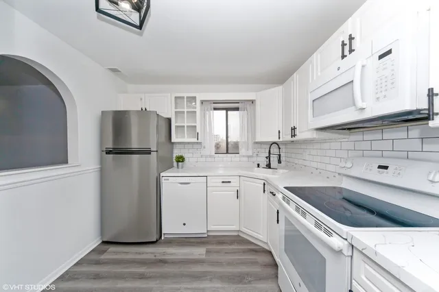 a kitchen with a refrigerator sink and white cabinets
